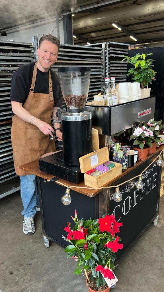 De mobiele koffiebar opgesteld met bloemen erbij