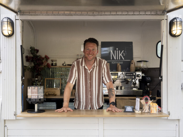 Nik achter de toonbank van zijn koffiebar