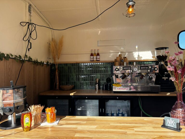 De bar van binnen, met de espressomachine en de toonbank