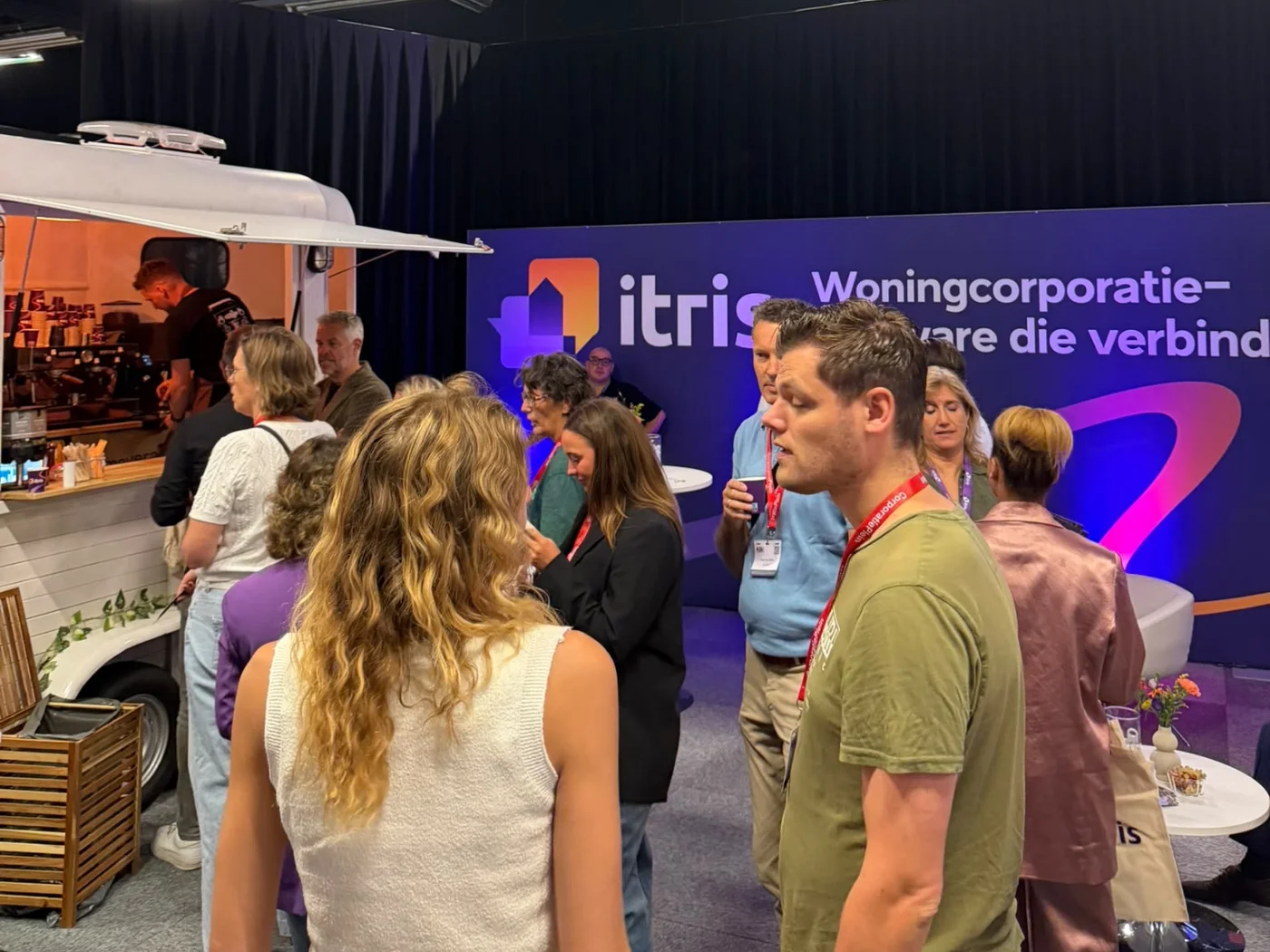 Bezoekers halen koffie bij de mobiele koffiebar op een beursstand