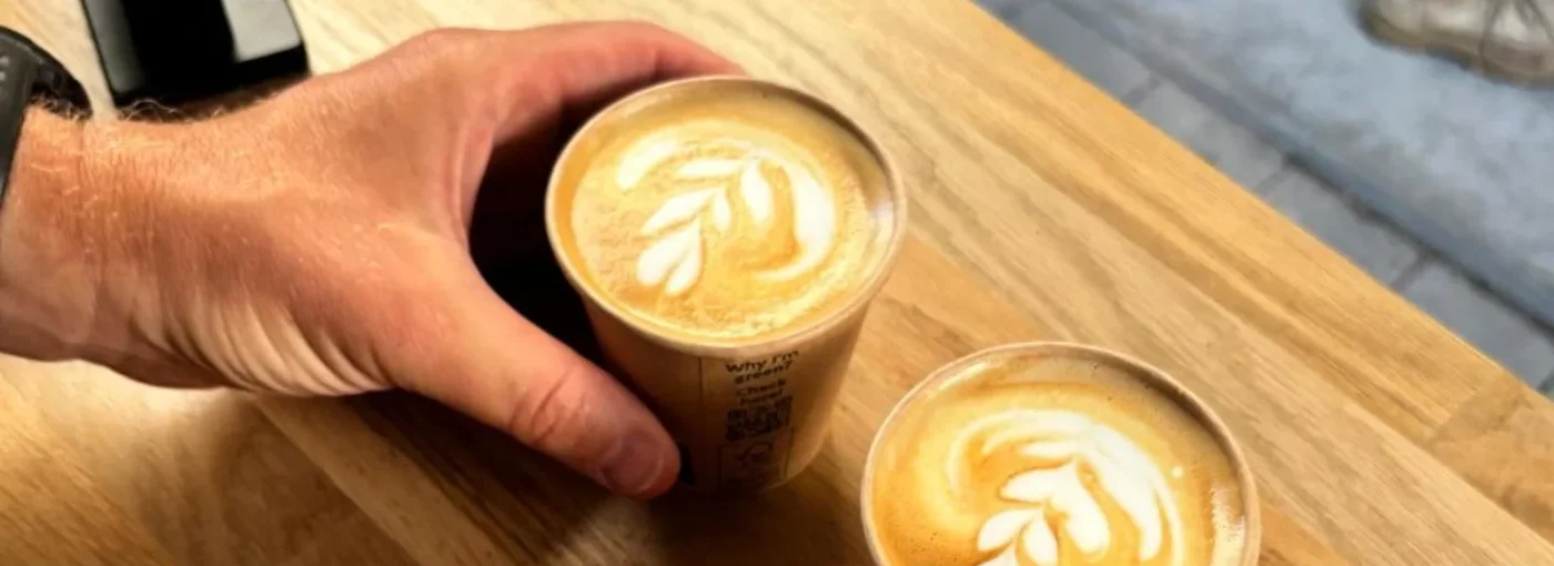 Twee kopjes cappuccino met latte art op de bar van Nik’s Koffiebar